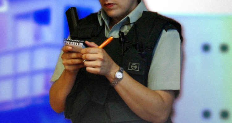 Una funcionaria de gendarmería mirando una libreta de notas.