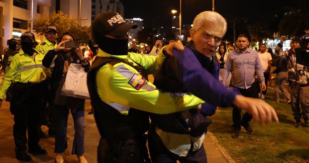El jefe de Cancillería de la Embajada de México forcejea con policías.