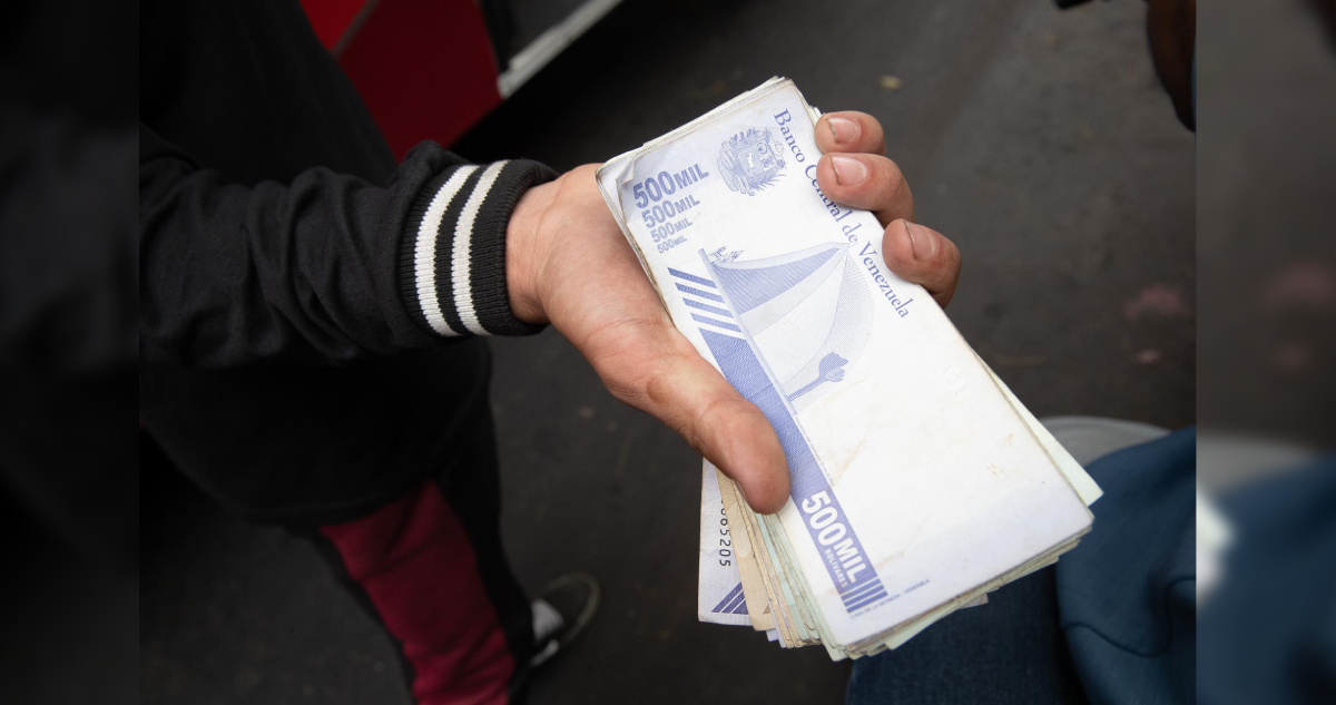 Un trabajador del transporte público muestra un fajo de bolívares, en Caracas (Venezuela) 30 de marzo de 2023