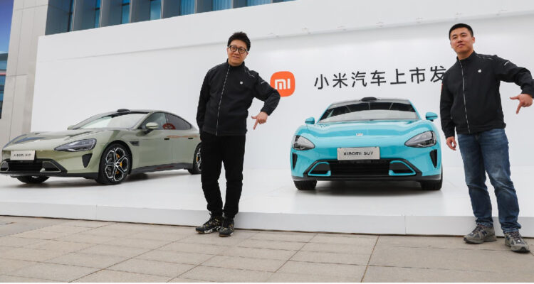 visitantes posan para una foto frente a los coches eléctricos Xiaomi SU7 en el Centro Internacional de Convenciones y Exposiciones Etrong de Beijing, en Beijing, China, 28 de marzo de 2024