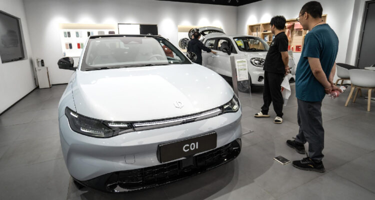la gente mira vehículos eléctricos dentro de una sala de exposición de Leapmotor en Beijing, China, 15 de mayo de 2024