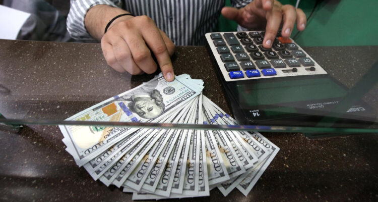 hombre cuenta varios billetes de dólar