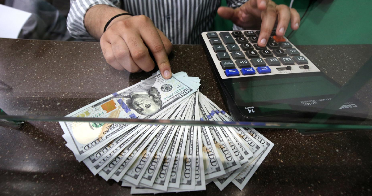 hombre cuenta varios billetes de dólar