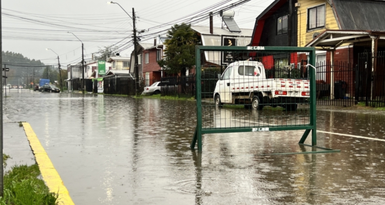 Vecinos cortan tránsito de calles en Valdivia por inundación.