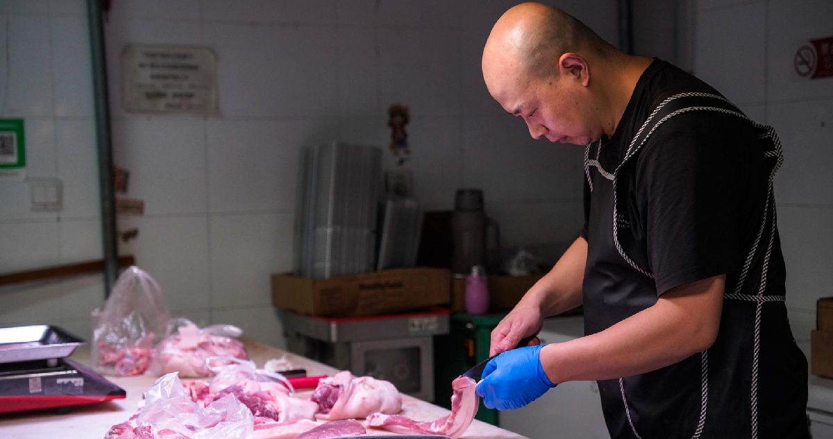 Un vendedor corta carne de cerdo local en un mercado de Pekín (China), hoy 17 de junio de 2024.