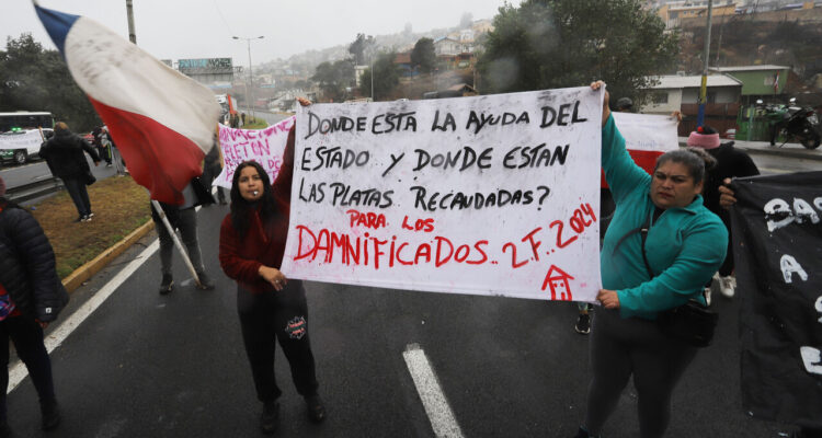 Personas damnificadas por los incendios de febrero en Viña del Mar, protestan en el paradero 10 de Achupallas por la demora en la entrega de viviendas de emergencia.