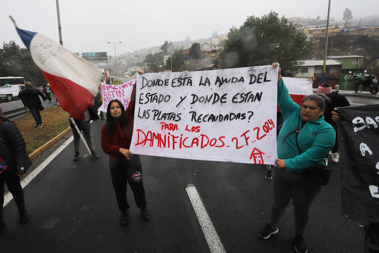 Personas damnificadas por los incendios de febrero en Viña del Mar, protestan en el paradero 10 de Achupallas por la demora en la entrega de viviendas de emergencia.