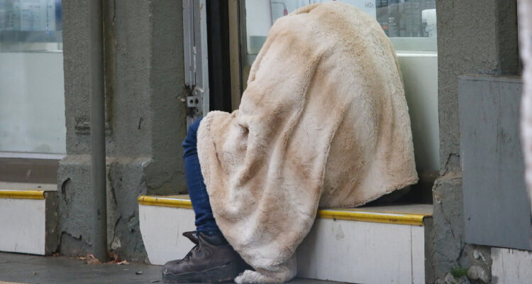 imagen archivo de una persona en situación de calle arropada en una sábana