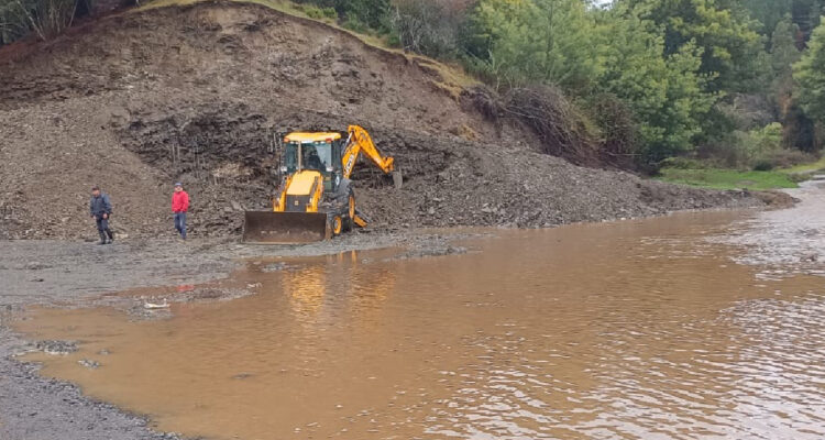 imagen de una retroexcavadora en medio de una poza con agua