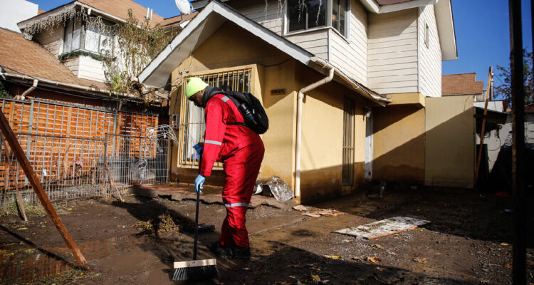 hombre limpiando casa afectada por lluvias