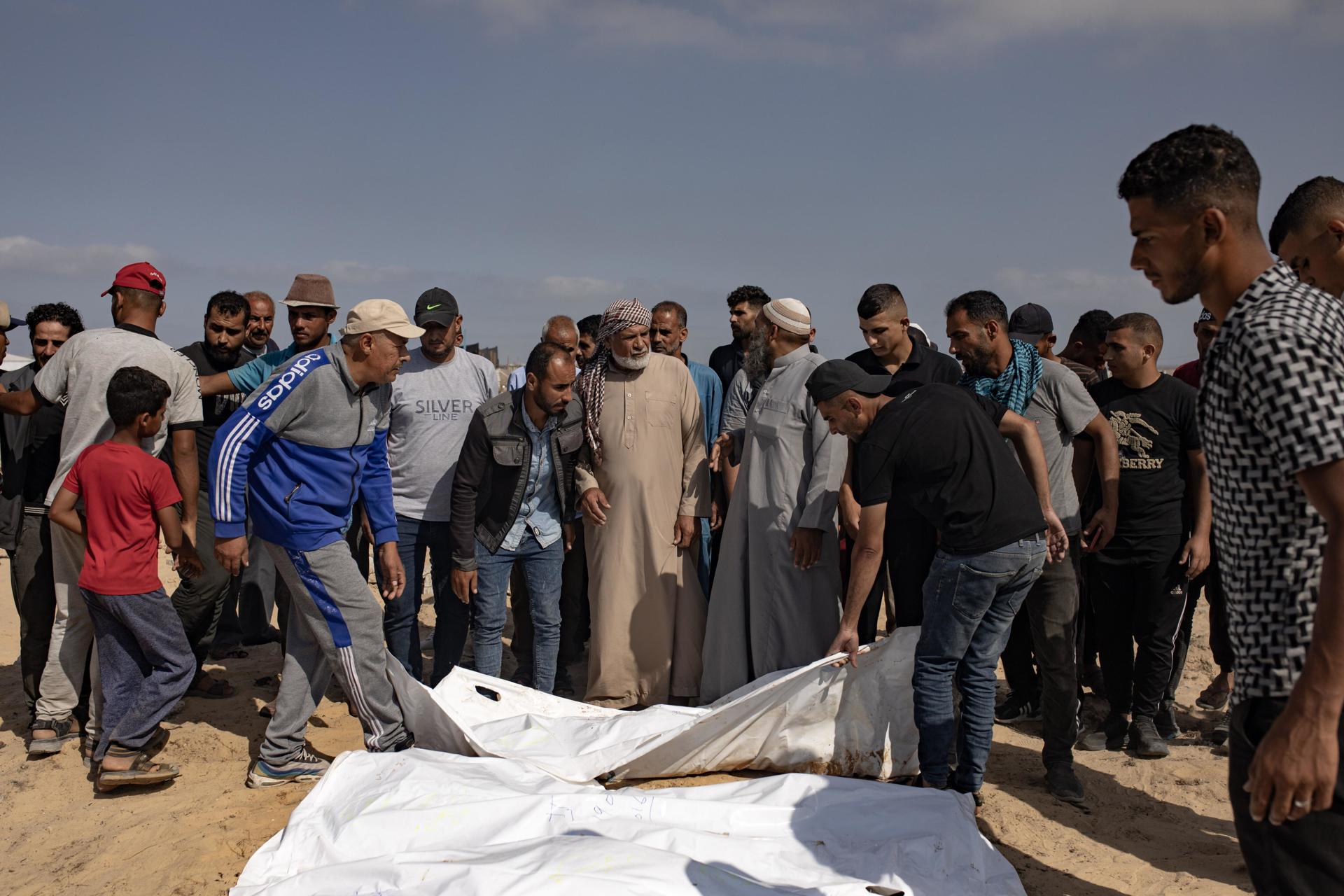 Palestinos cargan los cuerpos de sus familiares en el campamento de Jan Yunis