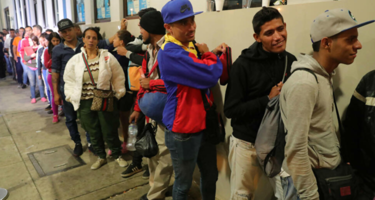 Venezolanos hacen fila en el puesto fronterizo de Tumbes, Perú