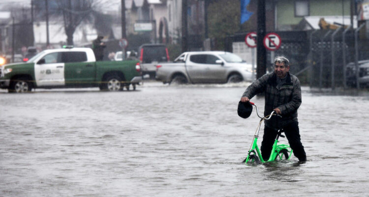 Una persona pasa con su bicicleta por una calle inundada , durarte el frente de mal tiempo que afecta a la zona.