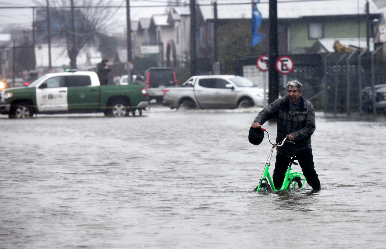 Una persona pasa con su bicicleta por una calle inundada , durarte el frente de mal tiempo que afecta a la zona.