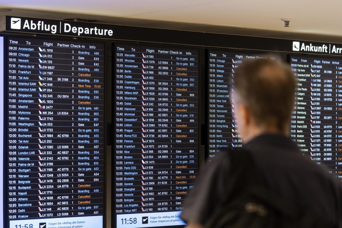 Los pasajeros miran las pantallas que informan en el aeropuerto de Zurich, Suiza