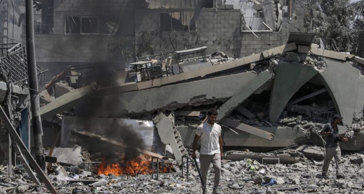 Palestinos junto a una escuela destruida tras un ataque aéreo israelí en la ciudad de Deir Al Balah, en Gaza