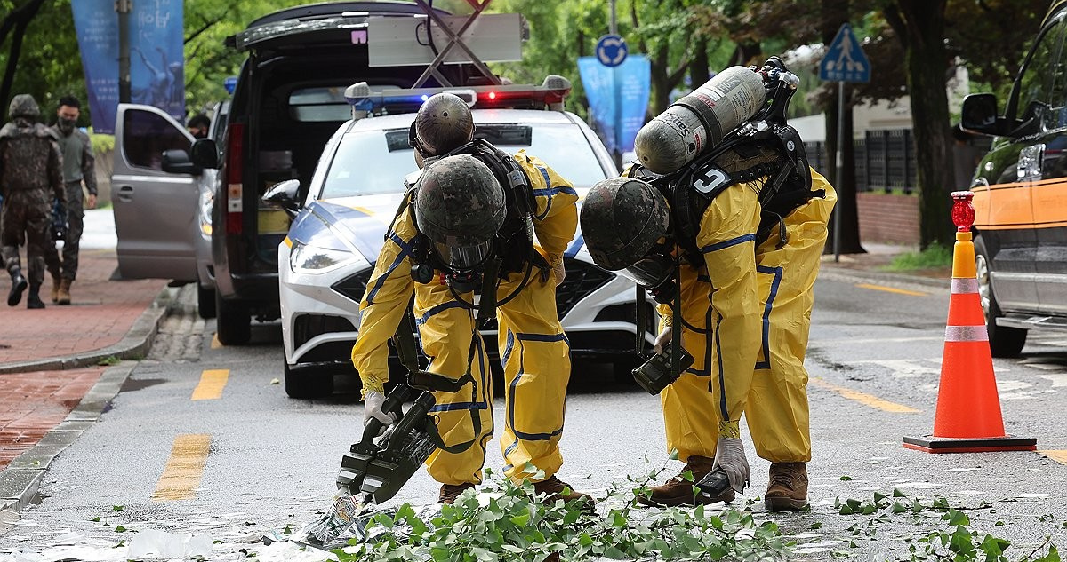 Militares recogen el contenido de un globo que transportaba basura que cayó en Seúl el 24 de julio | Yonhap