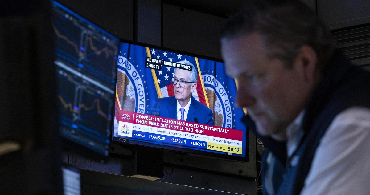 Un comerciante trabaja mientras el presidente de la Reserva Federal de Estados Unidos, Jerome Powell, aparece en las pantallas de televisión, en el piso de la Bolsa de Valores de Nueva York en Nueva York, Nueva York, Estados Unidos, el 12 de junio de 2024.