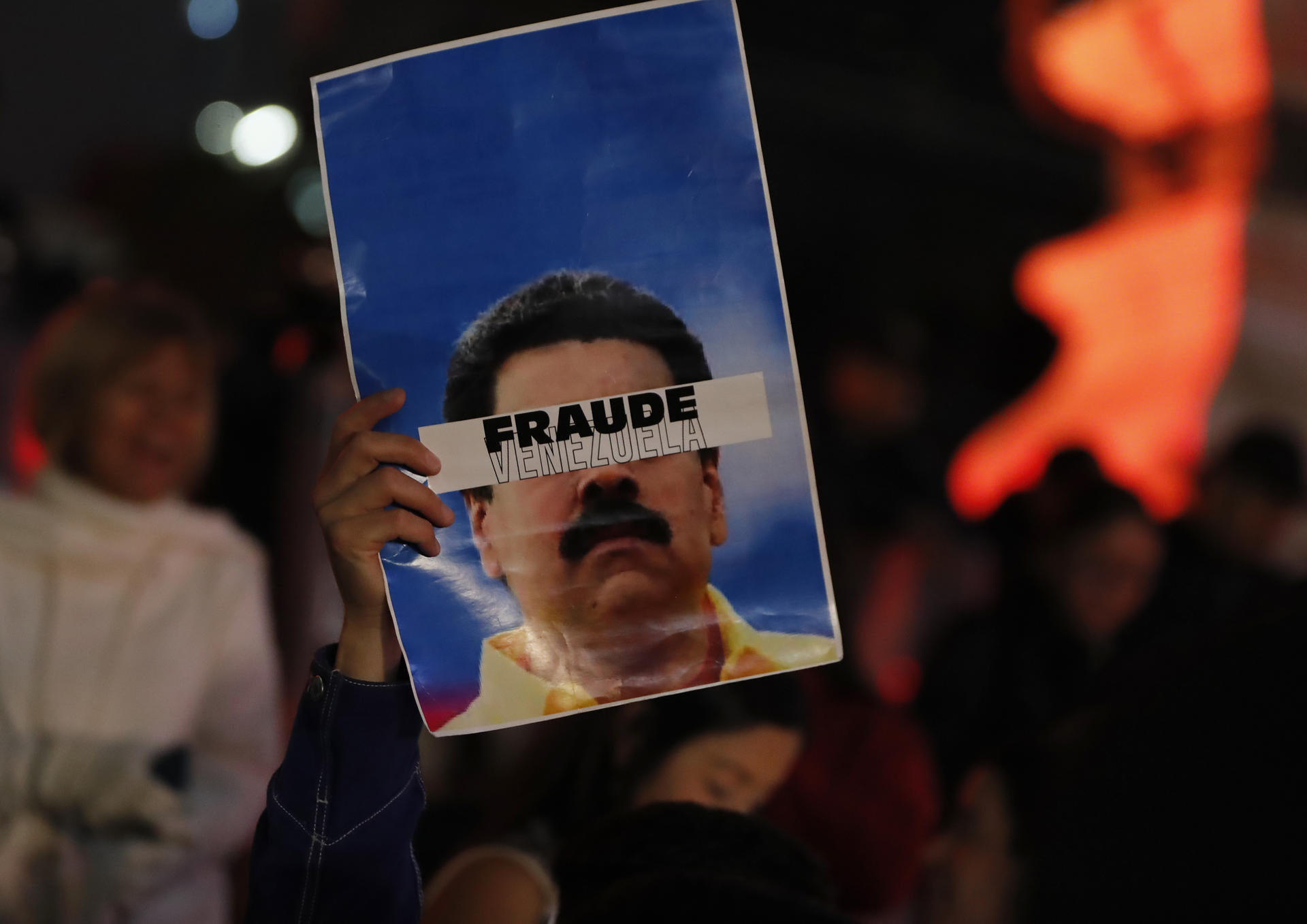 Una persona con un cartel que dice “Fraude Venezuela” en una protesta en Ciudad de México