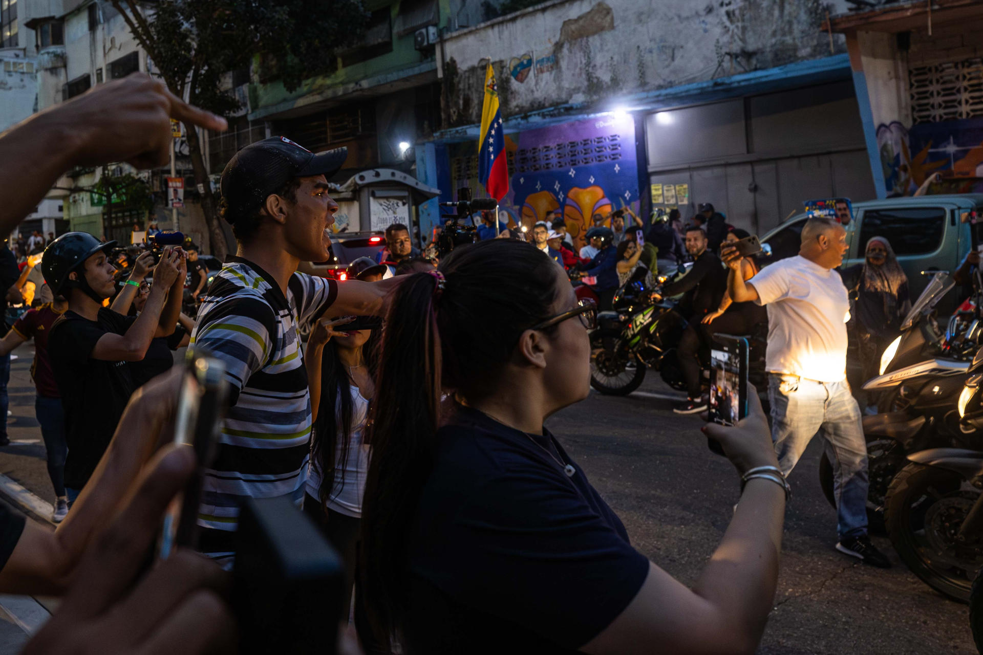 Chavistas se enfrentan desde una caravana de motocicletas con personas en Caracas