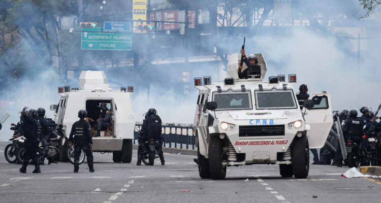 Integrantes de la Policía Nacional Bolivariana (PNB) enfrentan a manifestantes opositores el lunes