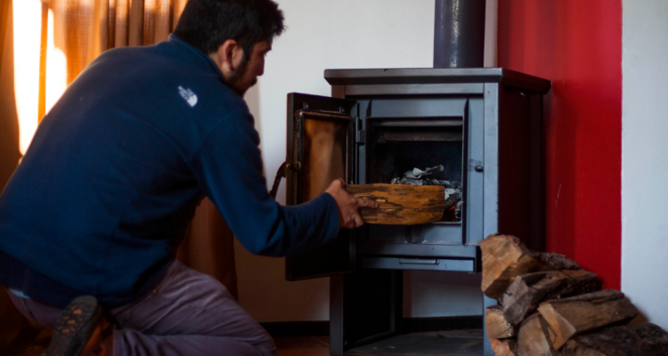 Persona usando leña en el marco de recambio de calefactores por PDA en Osorno