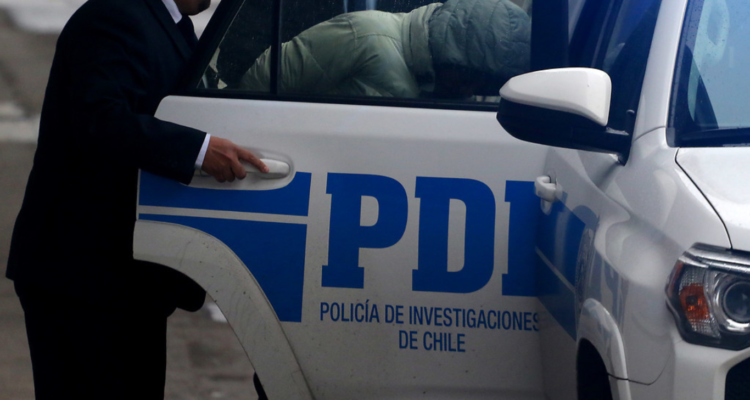 Imagen de un vehículo de la PDI con un detenido. Fotografía para dar contexto de una detención por tráfico de drogas en Concepción.