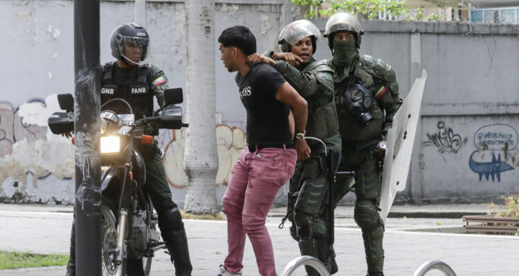 Integrantes de la Guardia Nacional Bolivariana detienen a un manifestante en Caracas