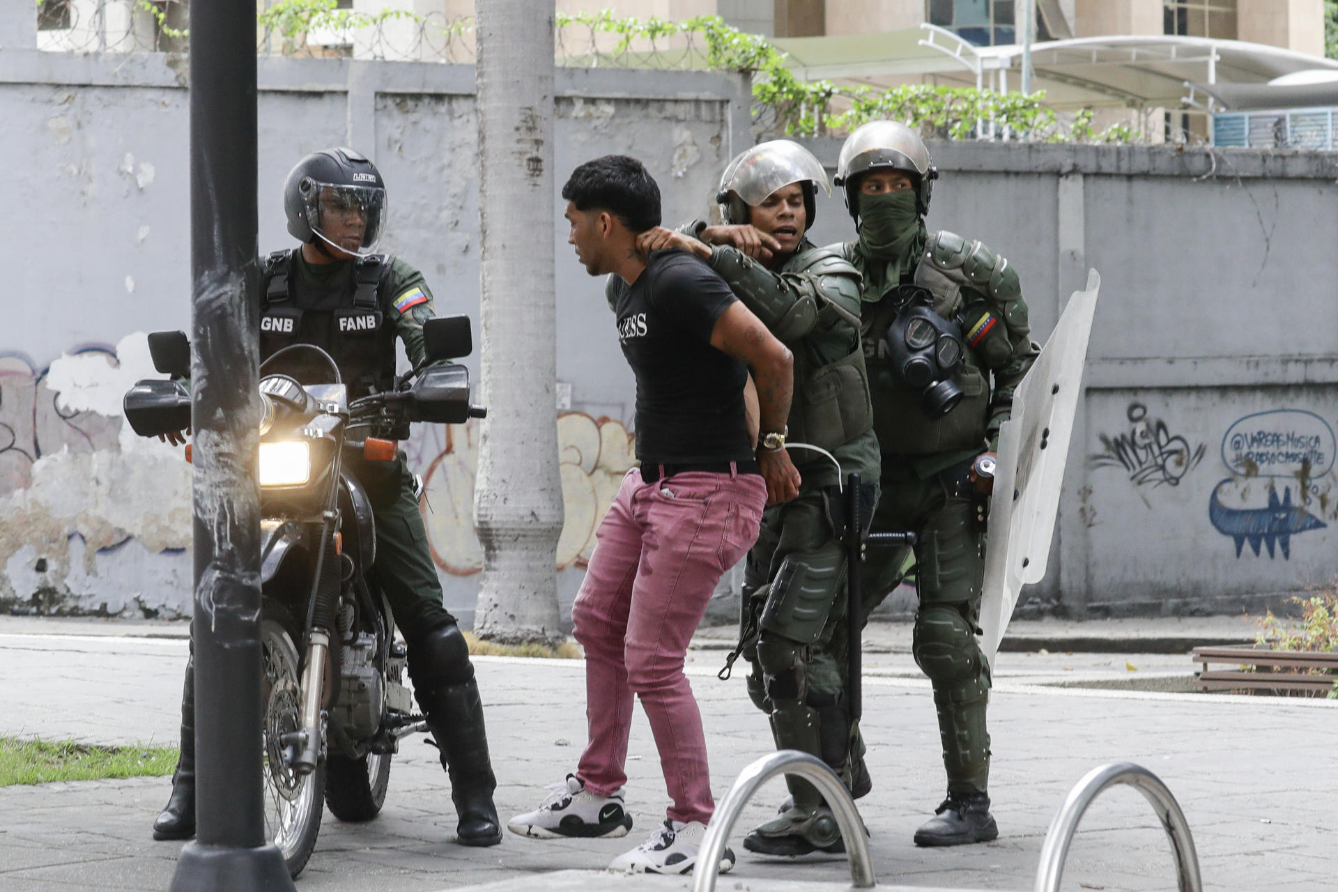 Integrantes de la Guardia Nacional Bolivariana detienen a un manifestante en Caracas