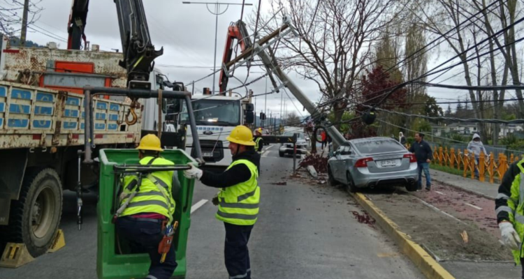 Personal de CGE reponiendo el poste caído por choque de conductor ebrio.