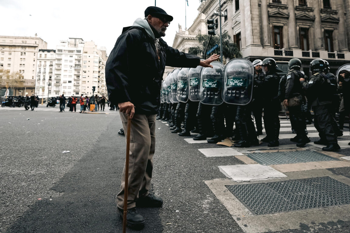 Un manifestante reacciona junto a integrantes de la policía en los alrededores del Congreso 