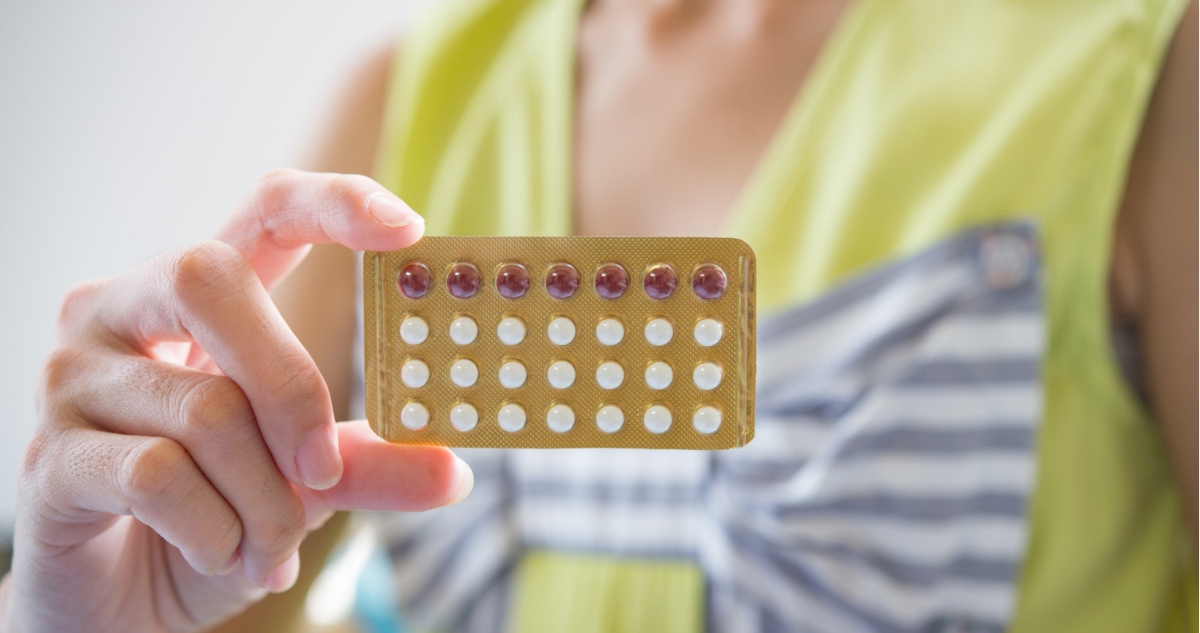 Mujer sosteniendo sobre de anticonceptivos