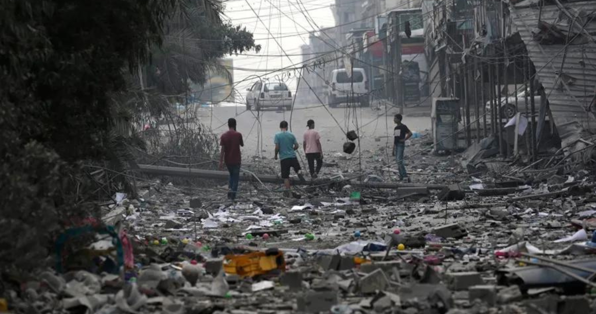 Un grupo de palestinos en una zona arrasada por los ataques israelíes en Gaza