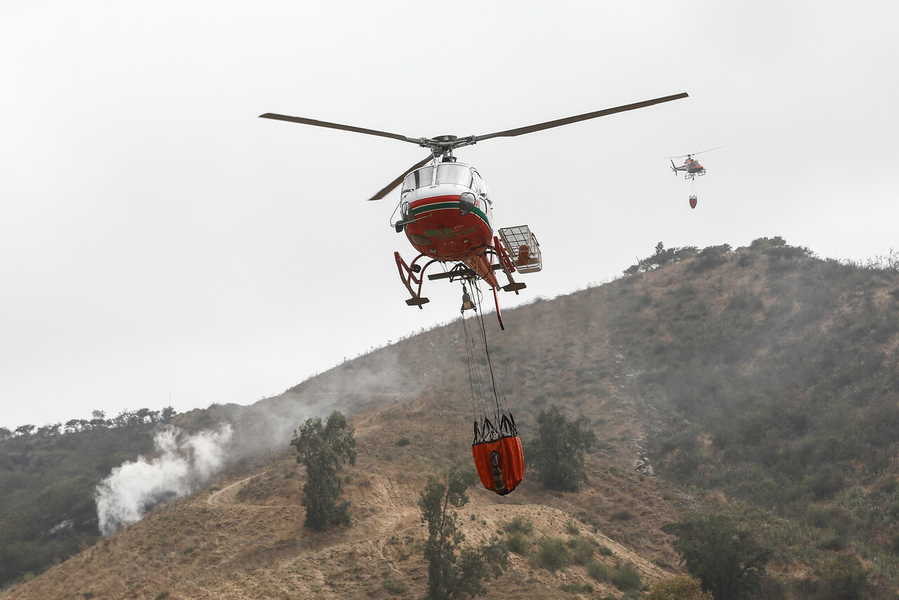 En la imagen, un helicóptero que combate un incendio forestal. Senapred declara Alerta Amarilla en Freirina por incendio forestal.