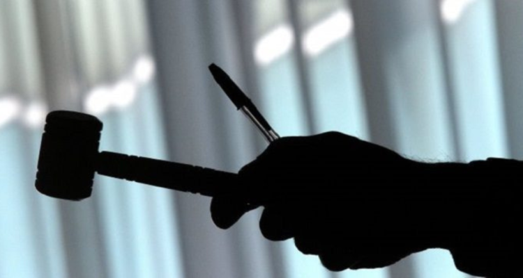 Mano sosteniendo mazo por juicio derivado de la fallida Operación Huracán