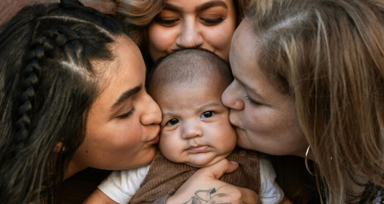 Foto de mujeres adultas besando a un bebé
