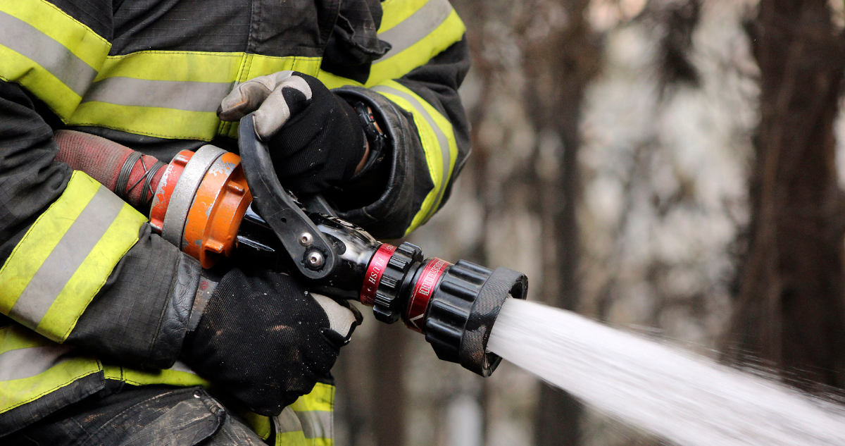 Imagen de un primer plano de un bombero combatiendo un incendio forestal.