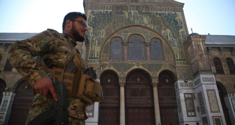 Un rebelde armado camina en la mezquita de los Omeyas en Damasco, Siria