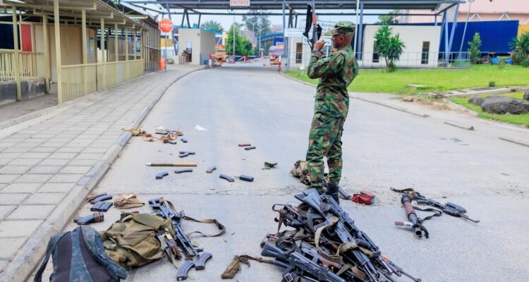 Un soldado inspecciona las armas requisadas a militares congoleños que se rindieron tras cruzar la frontera de Goma a Ruanda