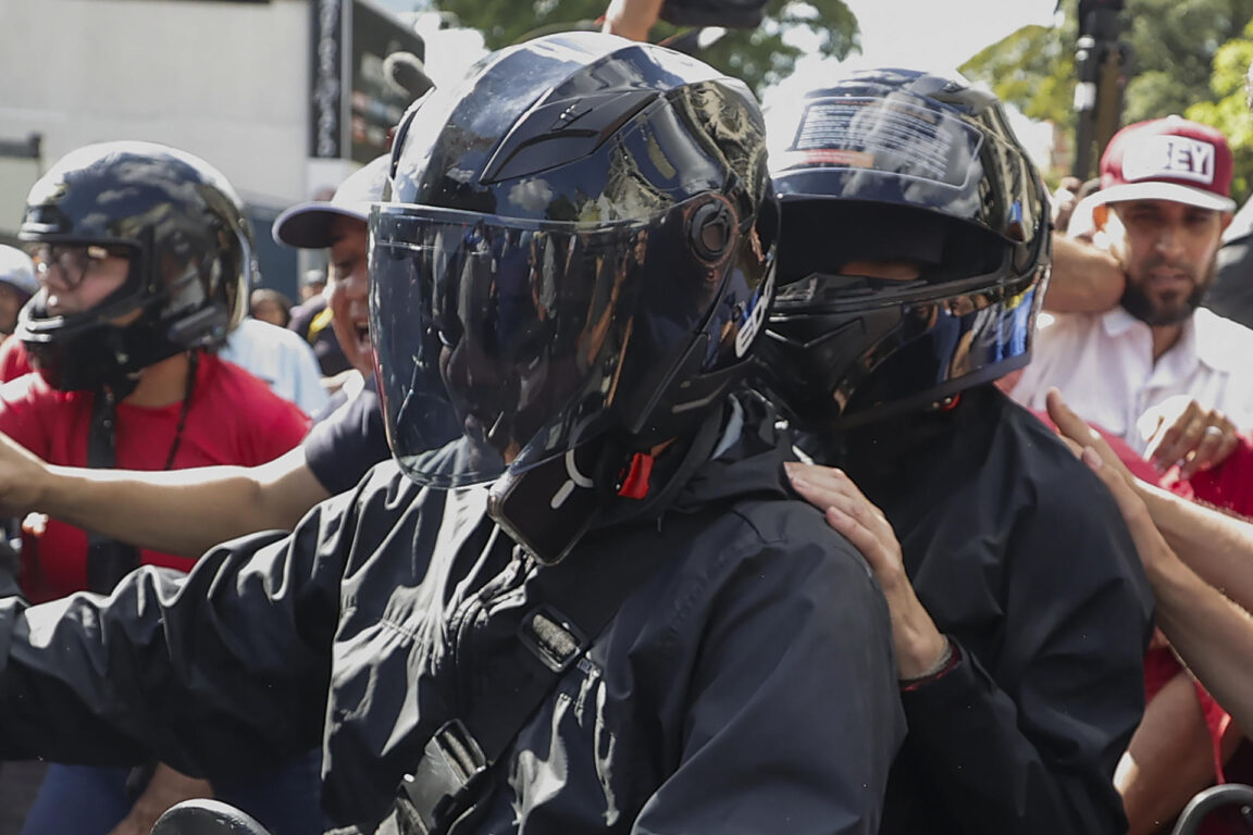 María Corina Machado (casco negro) se retira de una manifestación el jueves 