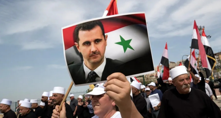 Imagen de archivo de un manifestante con una fotografía del presidente sirio, Bashar Al Assad