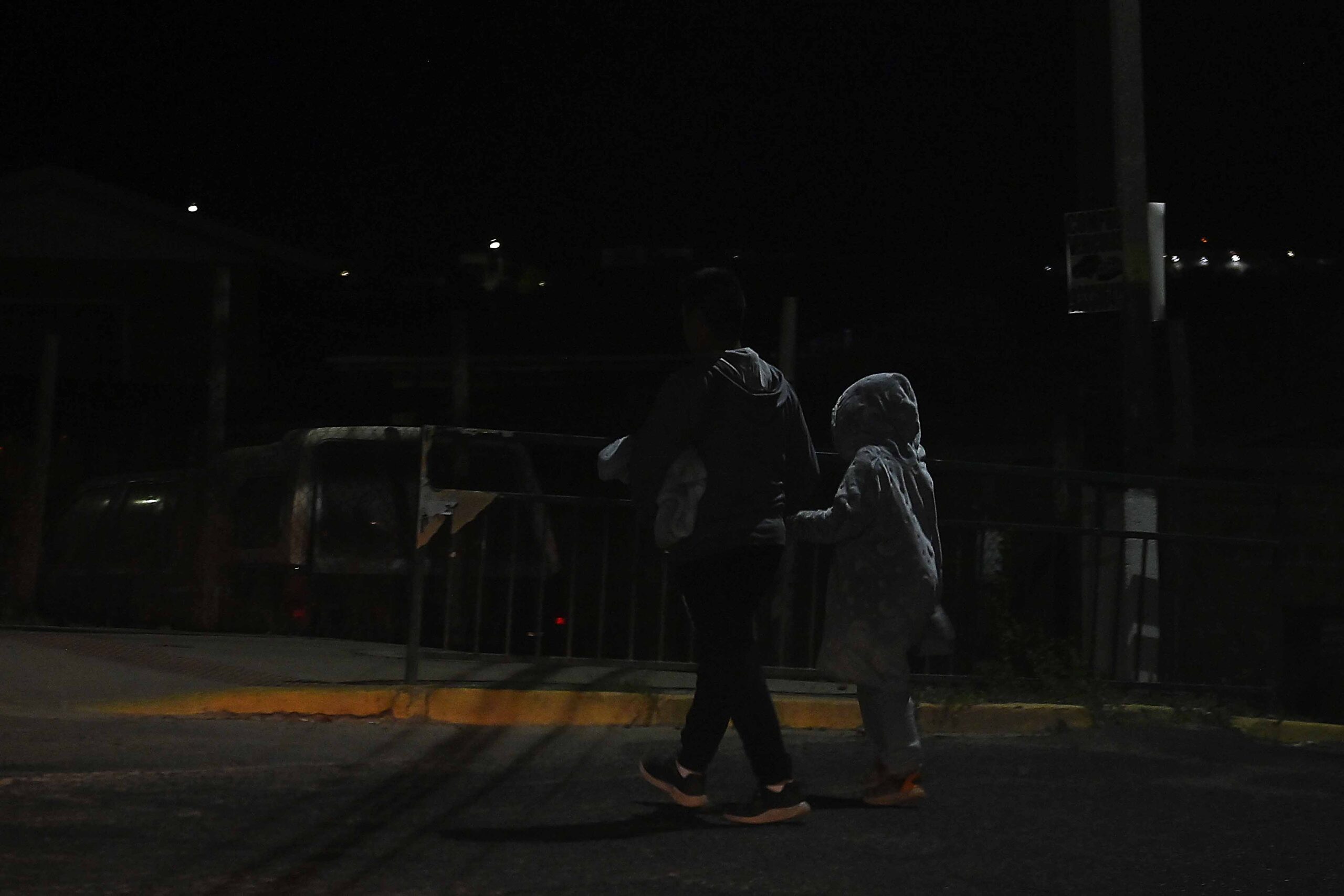 Personas paseando en la calle sin luz