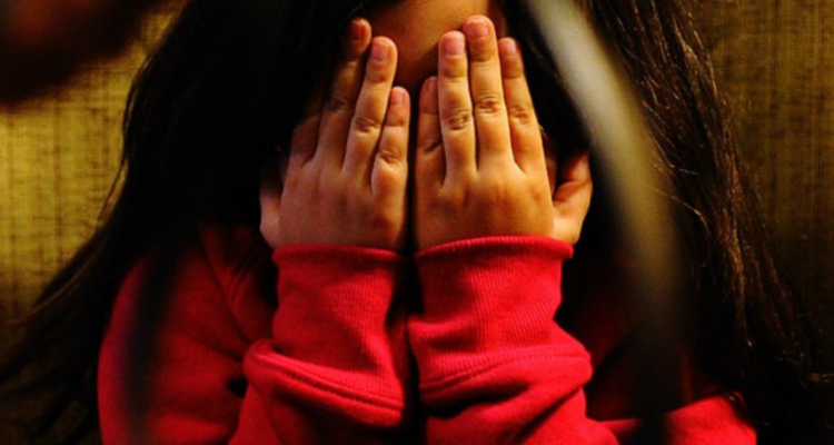 Niña tapándose la cara