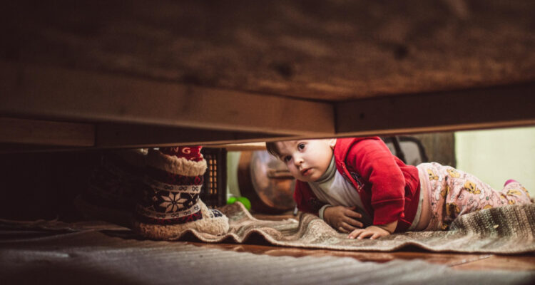Niño buscando un monstruo bajo su cama