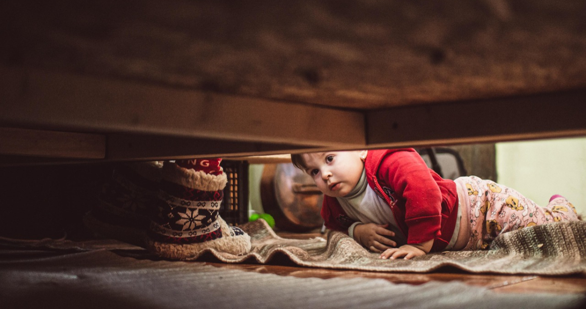 Niño buscando un monstruo bajo su cama