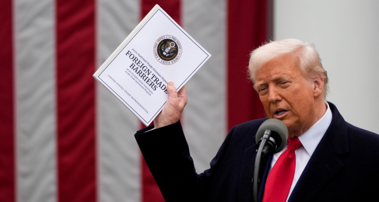 Donald Trump con carpeta de aranceles, bandera de Estados Unidos atrás.