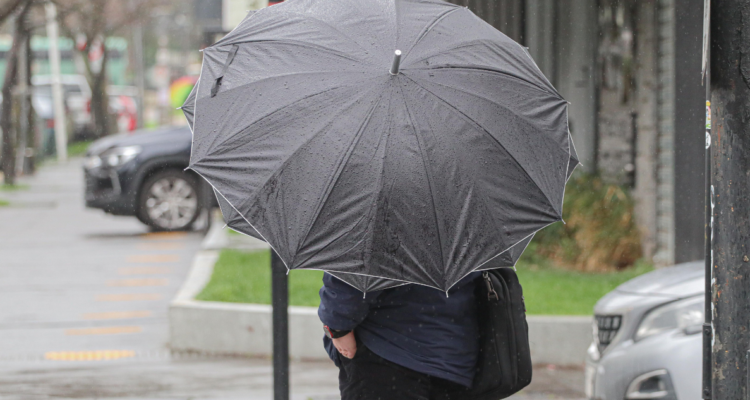 Persona usando paraguas por Alerta Temprana Preventiva en La Araucanía