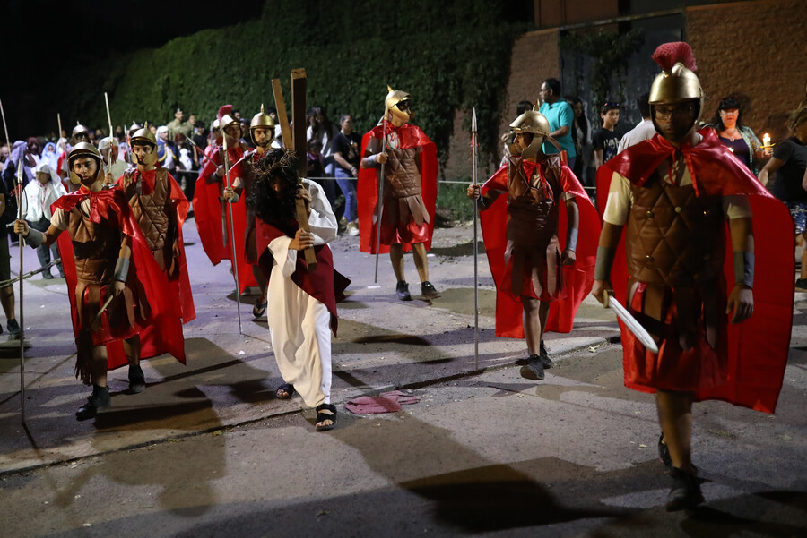 Fieles vestidos como soldados romanos participan en una recreación del Vía Crucis en Colina en el marco del Viernes Santo.