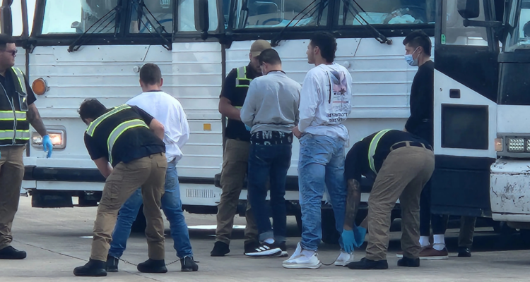 Archivo | Oficiales de migración revisan a migrantes antes de ser deportados en el Aeropuerto de Harlingen, Texas