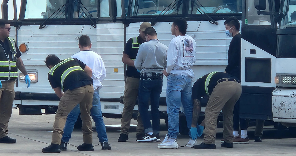 Archivo | Oficiales de migración revisan a migrantes antes de ser deportados en el Aeropuerto de Harlingen, Texas